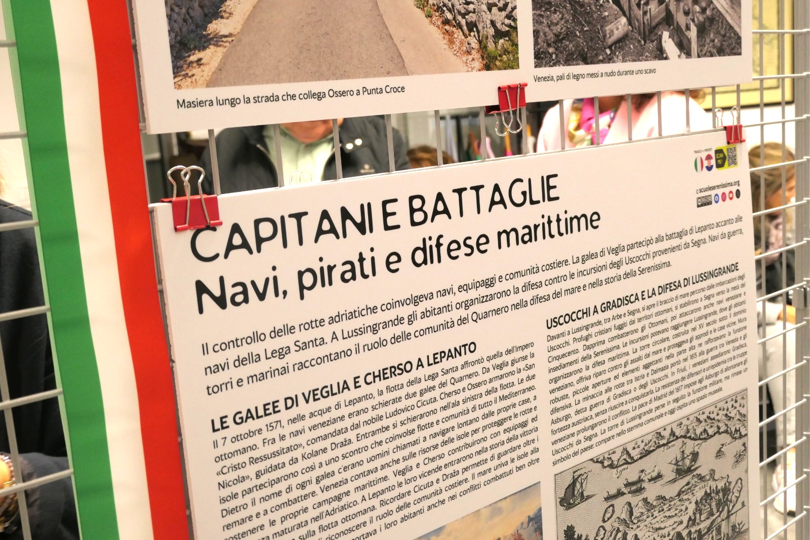 Poster informativo su capitani, navi e battaglie marittime, con testi in italiano e un'immagine di una strada tra Ossaro e Punta Croce.