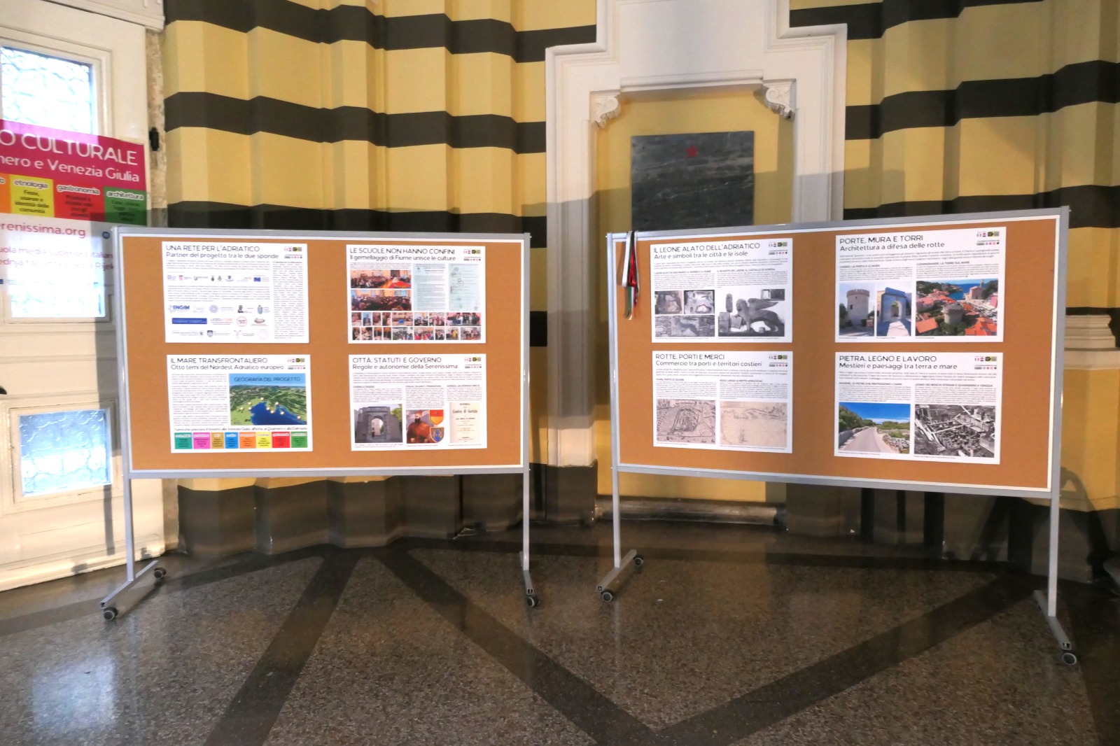 Esposizione di pannelli informativi su progetti culturali e storici del Friuli Venezia Giulia, inclusi tematiche come trasporti, arte e cultura locale.